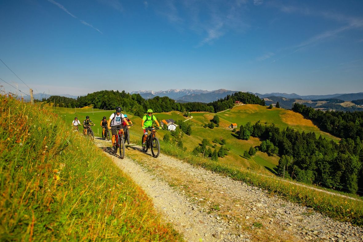 Cyclists on trail with mountain views in the sun