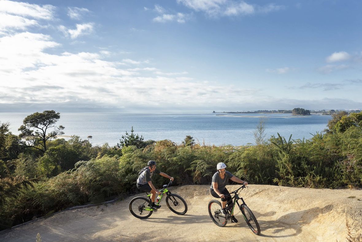 Two cyclists on mountain bike track by the sea