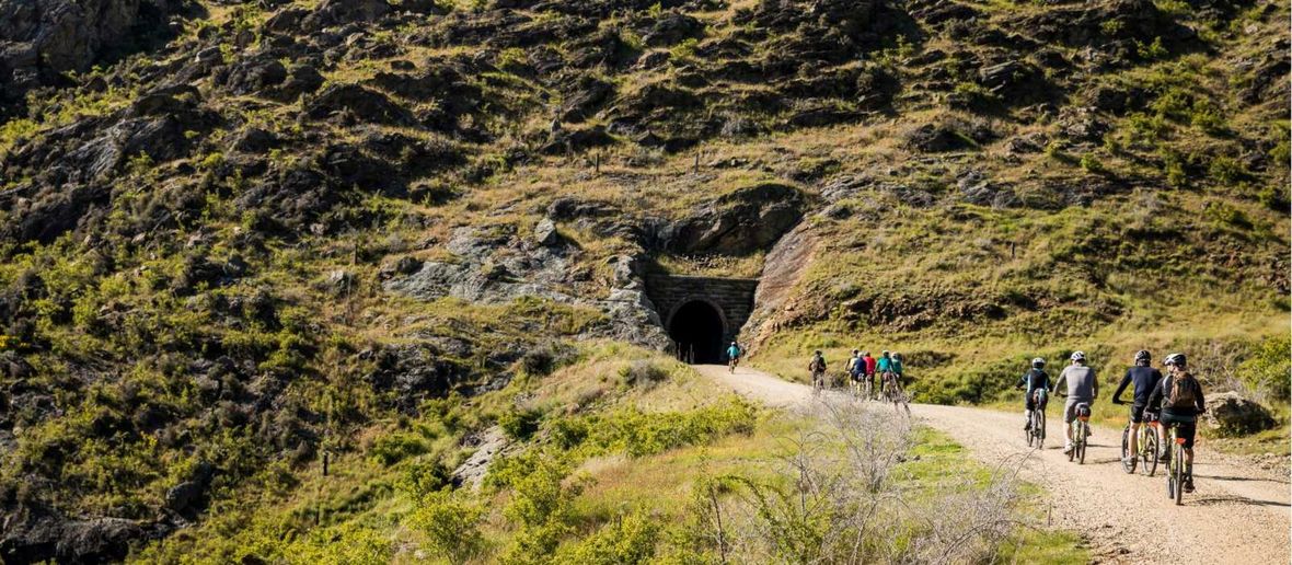 Cyclists off road cycling to a tunnel in a hill