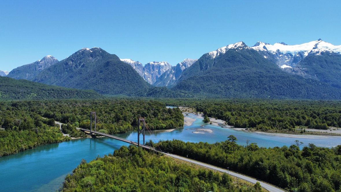 Snow-capped mountains, blue lakes and forests with a bridge
