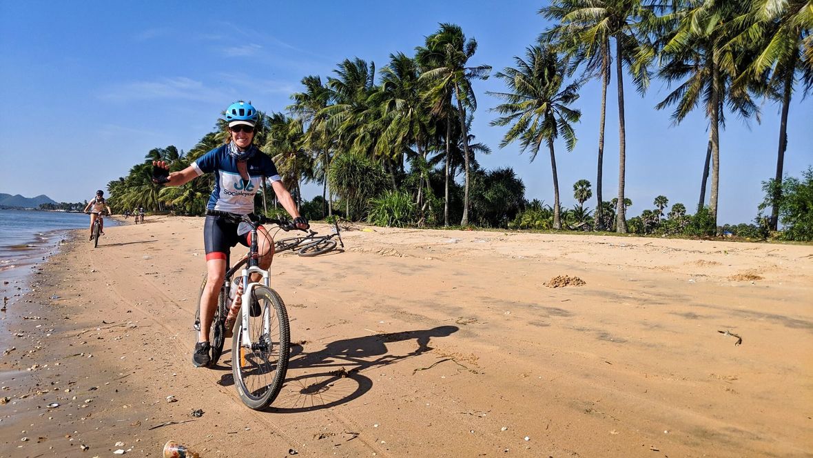 Cyclist riding on palm tree beach