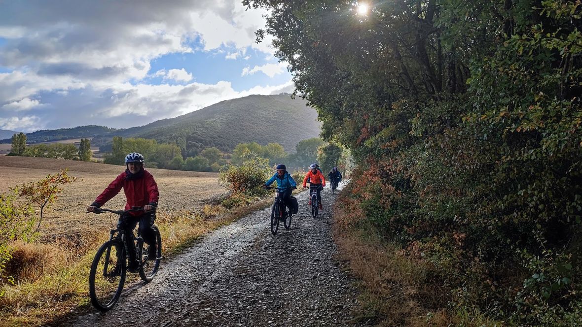 Cyclists on gravel path with hills in background