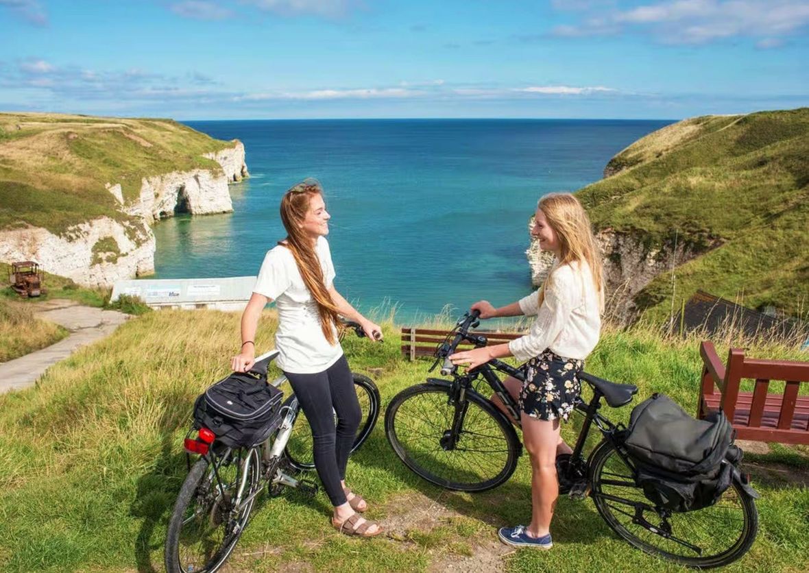 Two cyclists at top of cliff on bit of a windy day