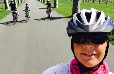 Cyclist taking a selfie with family behind