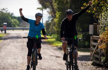Two cyclists with fist in the air