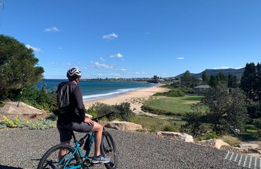 Cyclist stopping at beach viewpoint