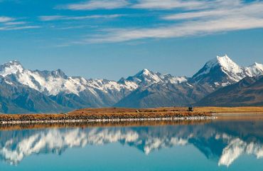 Snow-capped mountains reflecting in lake