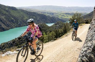 Cyclists on gravel path by water