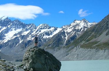 Person standing on rock with mountains in background
