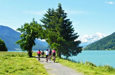 Group of cyclists riding next to the lake