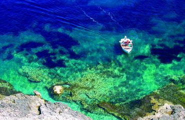 Small boat in clear blue water