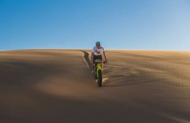 Cyclist riding a fat bike on a sand dune