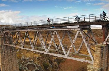 Cyclists riding acoss a rail bridge