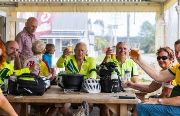 Group of cyclists sitting around a table enjoying a drink