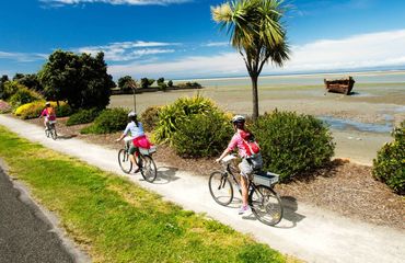 Cyclists riding a path by the sea