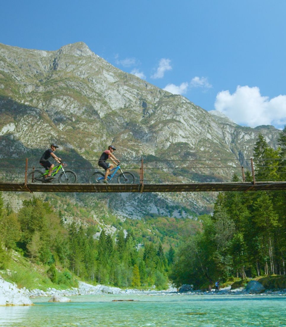 Marvel at the tranquil beauty of Soča River, where emerald-green waters weave through rugged landscapes 