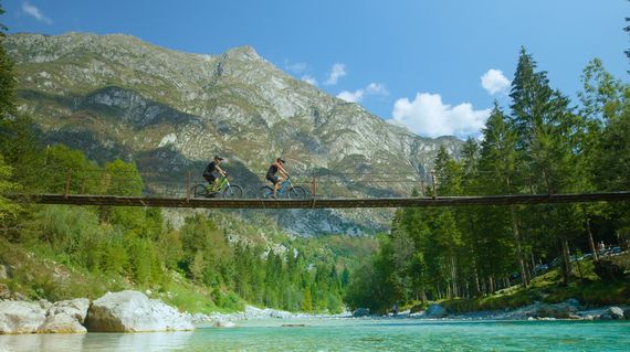 Marvel at the tranquil beauty of Soča River, where emerald-green waters weave through rugged landscapes 