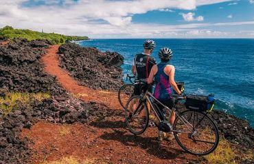 Cyclists looking at the ocean from a cliff