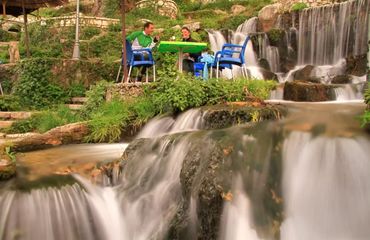 Couple sitting at a table by the side of waterfalls