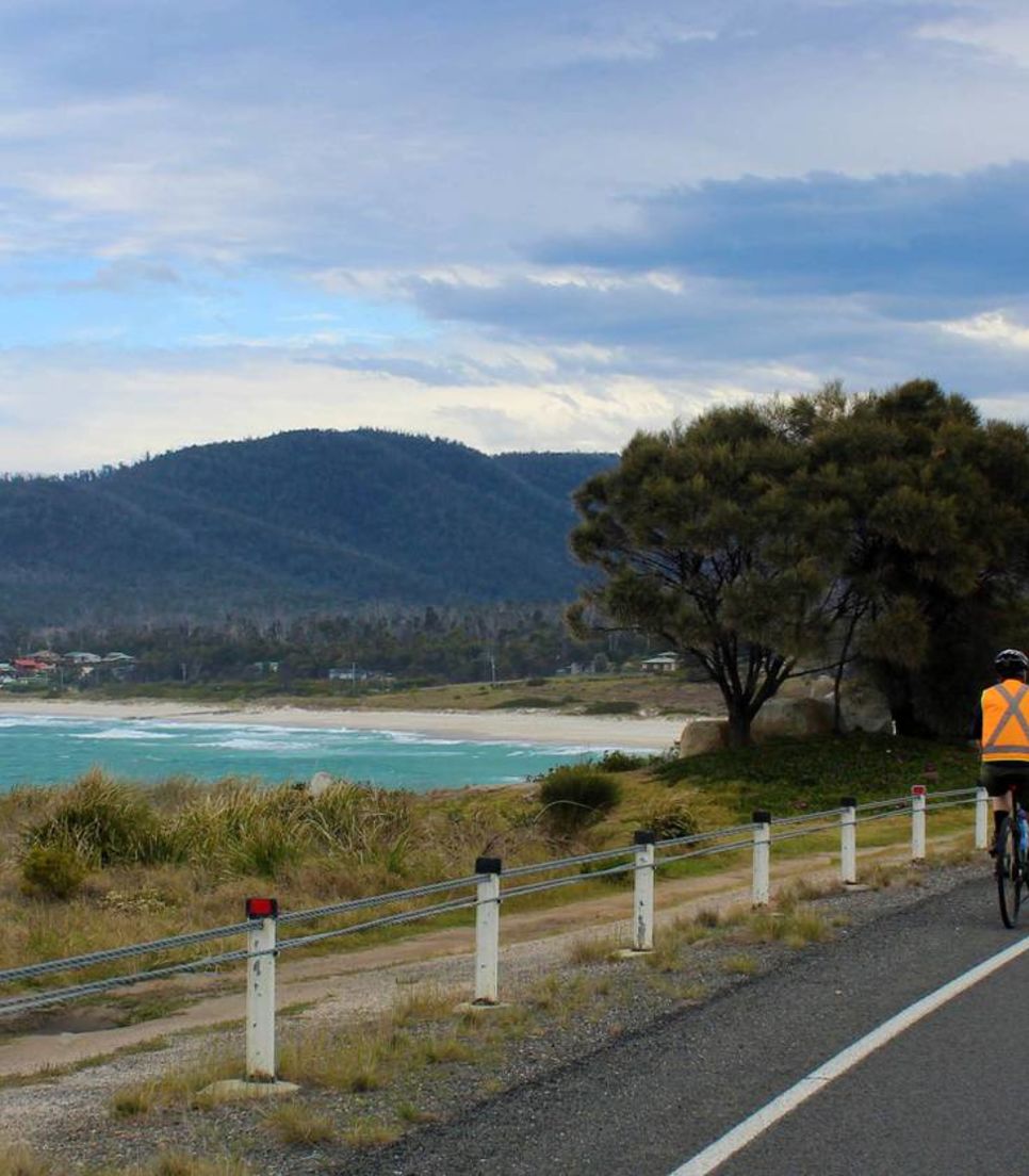 Feel the warm breeze as you cycle along the coast of Tasmania