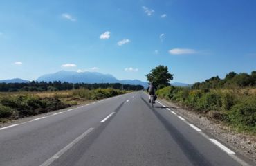Long road with road cyclist