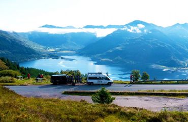 Van and cyclists as a viewpoint overlooking lake and mountains