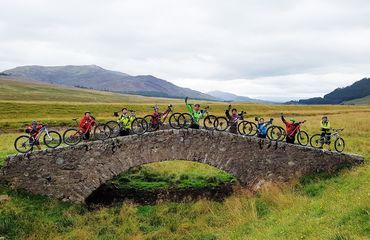 Cyclists standing on an historic bridge with their bikes