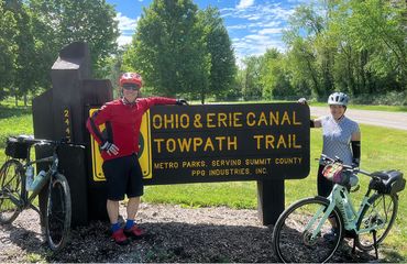 Couple of cyclists leaning on trail sign