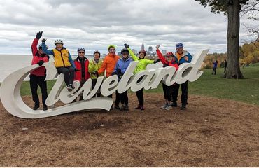 Group of cyclists infront of a Cleveland sign