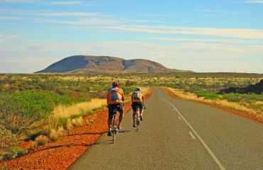 Cyclists biking on outback road