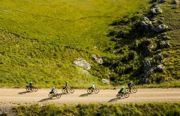 Cyclists riding on rural trail with green background