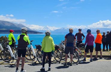 Group of cyclists taking a break looking over the water