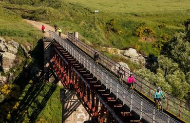 Cyclists riding across rail bridge