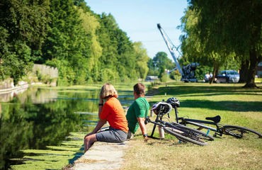 Cyclists resting on side of river