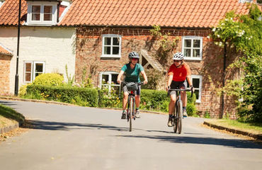 Cyclists riding through village