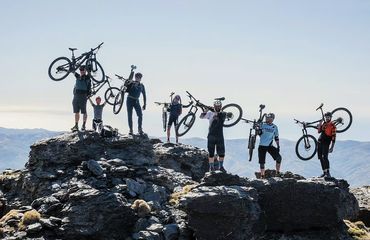 Mountain bikers carrying bikes over rocks