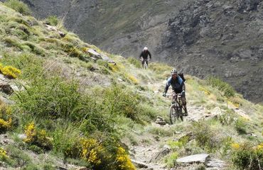 Cyclists riding down rocky hill