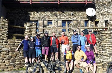 Group with a few bikes outside of historic stone building