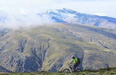 Lone cyclist and huge mountain behind