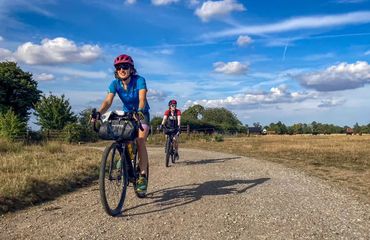 Cyclists riding along rural pathway