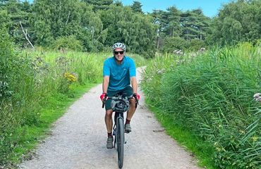 Cyclist on pathway with greenery all around