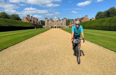 Cyclist on driveway to historic stately house