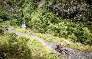 Cyclist riding through mountainous path