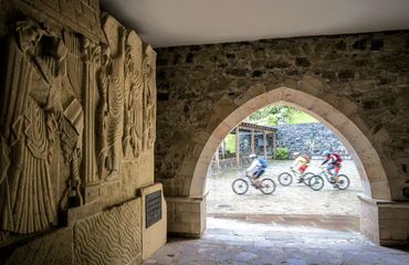 Cyclists riding past historic archway