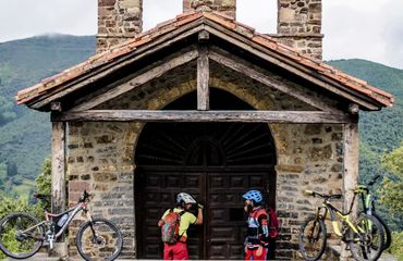 Cyclists knocking on door of small stone building