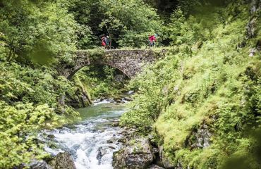 Cyclists on ancient bridge in nature