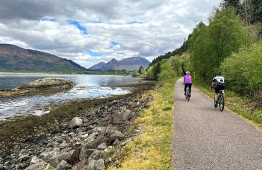 Cyclists on rural path by water