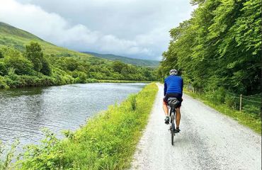 Cyclist riding by side of water