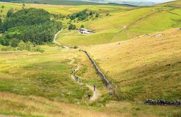 Aerial shot of cyclists riding countryside trail