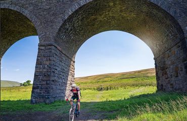 Cyclist riding under a viaduct/bridge